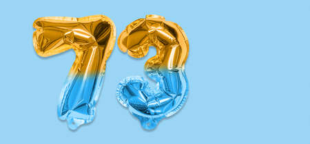 Rainbow foil balloon number, digit seventy three on a blue background. Birthday greeting card with inscription 73. Top view. Numerical digit. Celebration event template. Bannerの写真素材