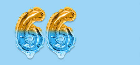 Rainbow foil balloon number, digit sixty six on a blue background. Birthday greeting card with inscription 66. Anniversary concept. top view. Numerical digit. Celebration event template. Bannerの写真素材