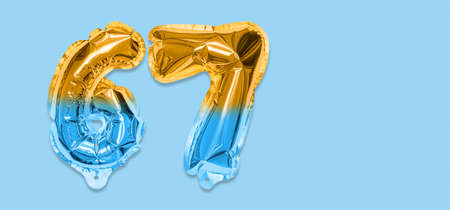Rainbow foil balloon number, digit sixty seven on a blue background. Birthday greeting card with inscription 67. Top view. Numerical digit. Celebration event template. Bannerの写真素材