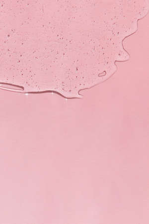 Transparent hyaluronic gel or serum on a pink background. skincare cosmetics product. wellness and beauty concept. top view.の写真素材