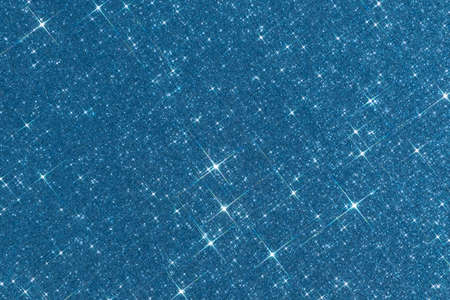 Sparkling texture. Abstract blue background with sparkles in the shape of stars. Festive backdrop for your projects.の写真素材