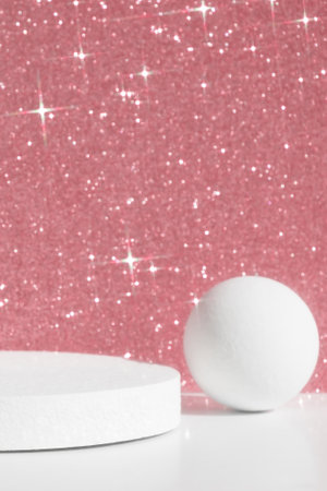 Geometric white podium on a pink shiny sparkling background for the presentation of a cosmetic product or gift. premium scene. Show case, display case.の写真素材