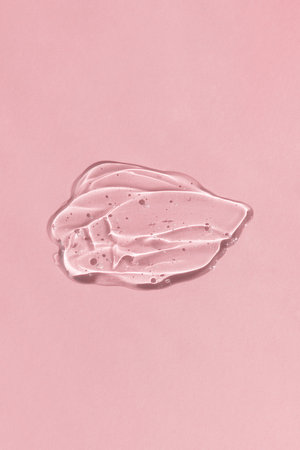 Transparent hyaluronic gel or serum on a pink background. Smear of skincare cosmetics product. wellness and beauty concept. top viewの写真素材
