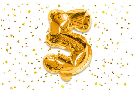 The number of the balloon made of golden foil, the number five on a white background with sequins. Birthday greeting card with inscription 5. Numerical digit, Celebration event, template.の写真素材