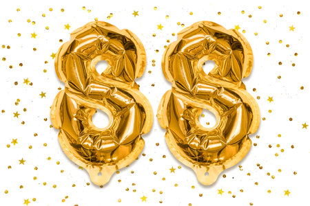 The number of the balloon made of golden foil, the number eighty-eight on a white background with sequins. Birthday greeting card with inscription 88. Numerical digit, Celebration event.の写真素材
