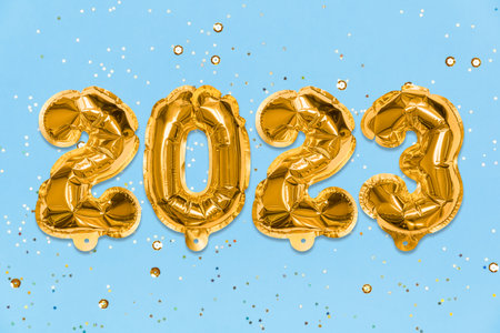 Golden foil balloon number, digit 2023 on a blue background with sequins. New Year's card. Happy new year celebration party. greetings and congratulation concept.の写真素材