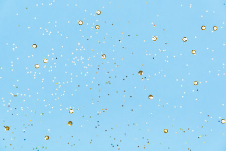 Blue background with golden sequins. Festive backdrop for your projects. background for your product presentation. christmas texture. Top view, copy space.の写真素材