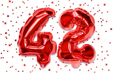 The number of the balloon made of red foil, the number forty-two on a white background with sequins. Birthday greeting card with inscription 42. Numerical digit. celebration event.の写真素材