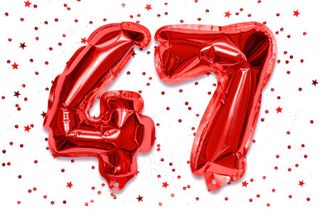 The number of the balloon made of red foil, the number forty-seven on a white background with sequins. Birthday greeting card with inscription 47. Numerical digit. celebration event.の写真素材