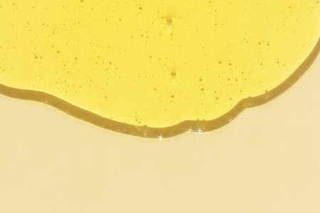 The texture of an antibacterial yellow gel or shampoo on a beige background. Serum or hyaluronic acid with bubbles. The concept of protection against viruses or cosmetics.の写真素材