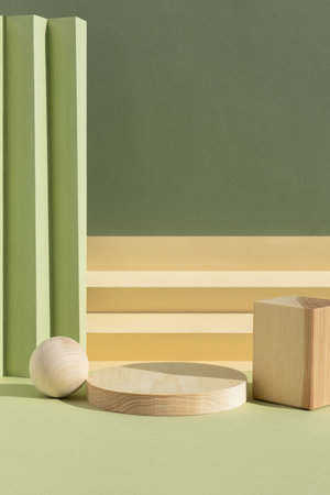 Wooden podium on an abstract green background. A scene with a geometric green and beige backdrop. Backdrop for the product presentation. Empty showcase, display case.の写真素材