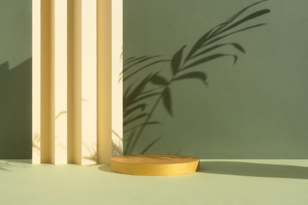 Golden podium on a green and beige background with shadow of palm leaves. Empty scene with a geometric background. Showcase, display case for the promotion of products, beauty, natural eco-cosmeticsの写真素材