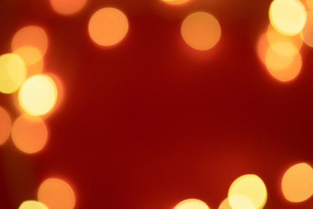 Golden abstract bokeh on a red background. The concept of the holiday. Christmas, New Year greeting card. Festive sparkling background. A place for your design.の写真素材