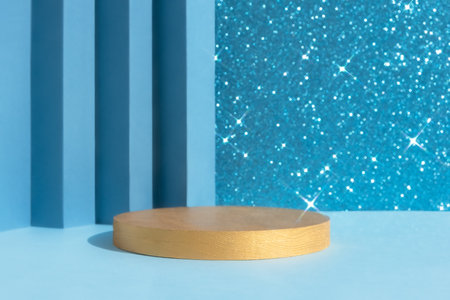 Golden podium on an abstract shiny sparkling blue background. A scene with a geometric backdrop. Showcase, display case for the presentation of a cosmetic product or gift.の写真素材
