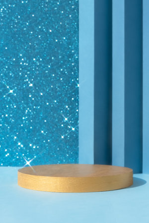 Golden podium on an abstract shiny sparkling blue background. A scene with a geometric backdrop. Showcase, display case for the presentation of a cosmetic product or gift.の写真素材
