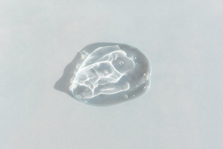 Transparent hyaluronic gel or serum on a gray background. Smear of skincare cosmetics product. Wellness and beauty concept. Top viewの写真素材