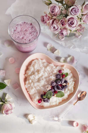 beautiful breakfast with porridge, flowers, yogurt and berriesの写真素材