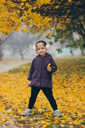 Adorable funny naughty little girl in park on beautiful autumn dayの写真素材