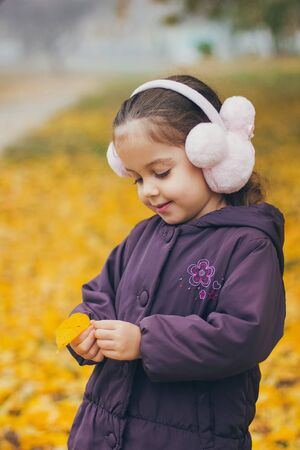 Adorable funny naughty little girl in park on beautiful autumn dayの写真素材
