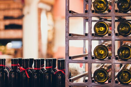 Closeup shot of wine shelf. Bottles lay over straw. Wine cellarの写真素材