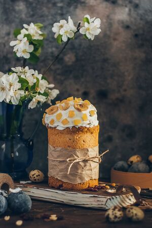 Traditional Russian Orthodox Easter bread kulich with apple blossom and colored eggs in rustic style...