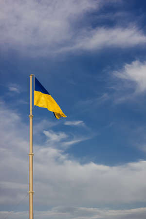 National yellow-blue flag of Ukraine waving on the blue sky background