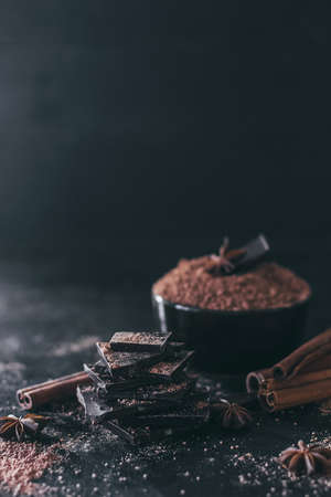 Chocolate bar pieces with cocoa powder on dark background, cope spaceの写真素材