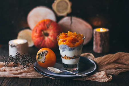 Delicious breakfast: chia seed pudding and persimmon close up in a glass on the table. horizontalの写真素材