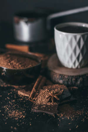 Chocolate bar pieces with cocoa powder. Cup of hot chocolate on dark backgroundの写真素材