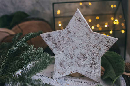 Christmas composition with nuts, garland, star, wooden decor rustic wooden box and fir tree branch....