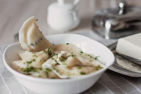 Dumplings, filled with potatoes and served with butter and fennel. Varenyky, vareniki, pierogi, pyrohy. Dumplings with fillingの写真素材