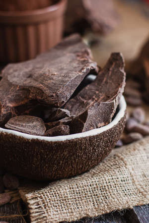 Unsweetened baking block chocolate, cocoa powder, cocoa butter and cocoa beans on old wooden background.の写真素材