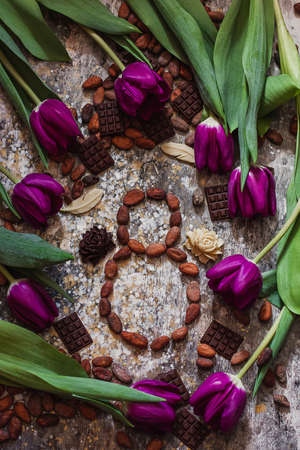 8 march, international womans day, eight from cocoa beans with purple tulips and handmade chocolates aroundの写真素材