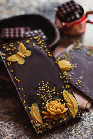Assortment of different creative chocolate types in wooden carved plate, with vintage props on the backgroundの写真素材