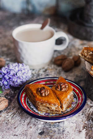 Assorted baklava. A Turkish ramadan arabic sweet dessert on a decorative plate, with coffee cup in the background. Middle eastern food baklava with nuts and honey syrupの写真素材