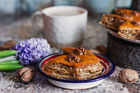 Assorted baklava. A Turkish ramadan arabic sweet dessert on a decorative plate, with coffee cup in the background. Middle eastern food baklava with nuts and honey syrupの写真素材