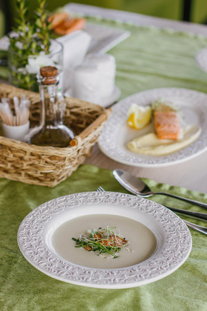 Cheese soup with salmon in green interior background.の写真素材