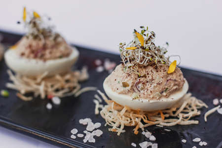 Deviled eggs, stuffed eggs filled with a paste made from smoked ham, mayonnaise, egg yolks and fresh microgreen. Tasty Easter breakfast, appetizer for party or holiday mealsの写真素材
