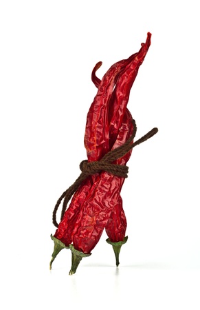 Three red chili peppers tied by rope on the white backgroundの写真素材