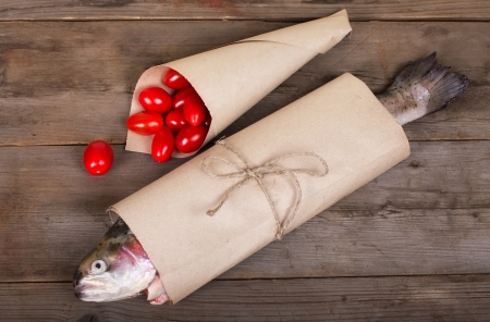 Fresh salmon with small tomatoes in the paper-packの写真素材