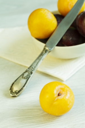 Many plums and knife on the tableの写真素材