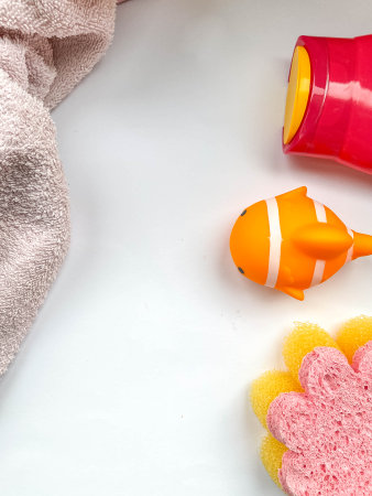 baby bath kit. A flower-shaped washcloth, rubber toys, foam and shampoo for bathing a child on a...