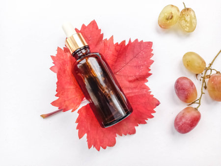 Flower and grapeseed oil. A bottle of oil and plants on a white background.の写真素材