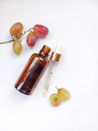 Flower and grapeseed oil. A bottle of oil and plants on a white background.の写真素材