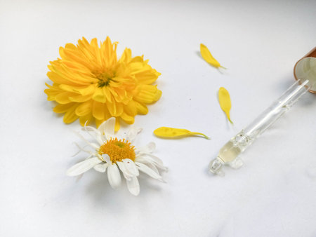Flower and grapeseed oil. A bottle of oil and plants on a white background.の写真素材