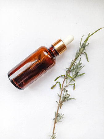 Flower and grapeseed oil. A bottle of oil and plants on a white background.の写真素材