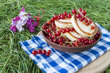 pancakes with fresh berries on a background of green grassの写真素材