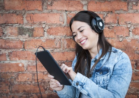 beautiful girl with a tablet near the wallの写真素材