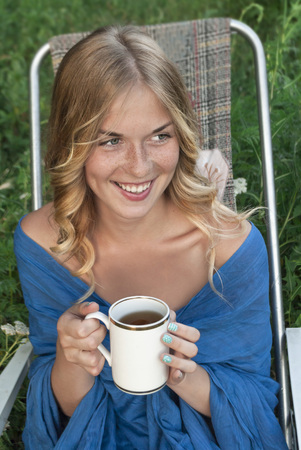 beautiful girl with blond hair is drinking teaの写真素材