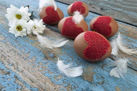 Easter eggs and feathers on a wooden surfaceの写真素材